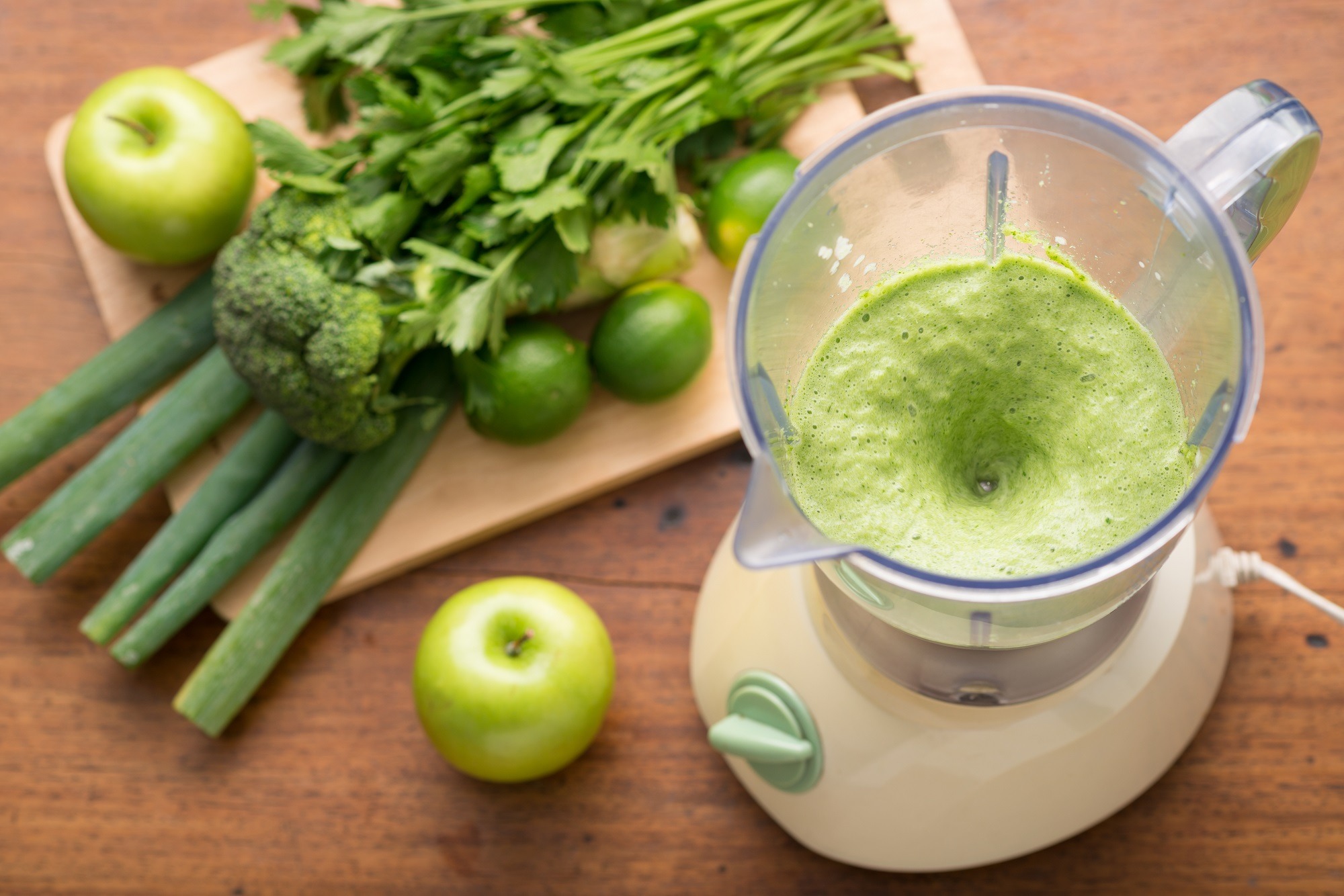 Blender with green fruits and vegetables