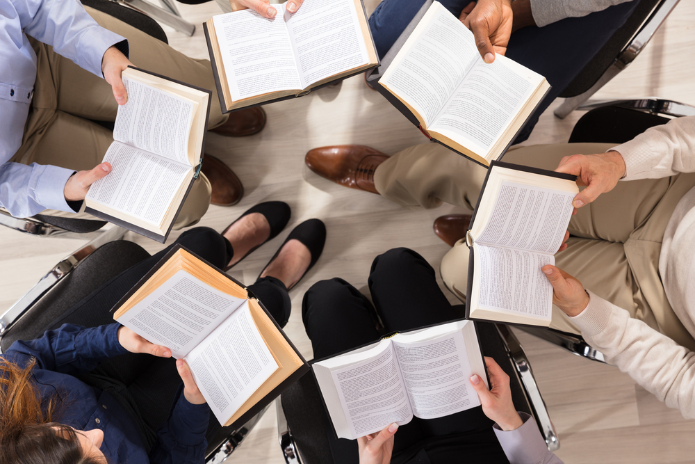 Elevated View Of People Sitting On Chair In Circle Reading Books